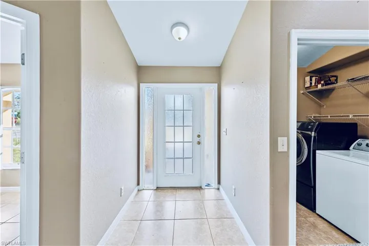 Entryway featuring separate washer and dryer and light tile patterned flooring