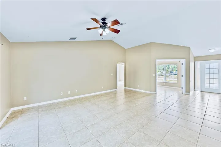 Tiled spare room with ceiling fan and lofted ceiling