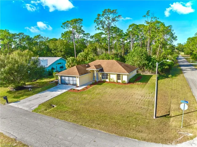 View of front of property featuring a garage and a front lawn
