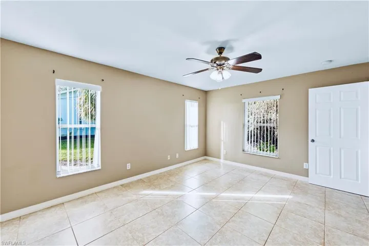 Tiled spare room featuring ceiling fan