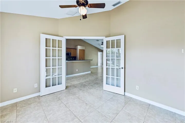 Tiled spare room with ceiling fan and french doors