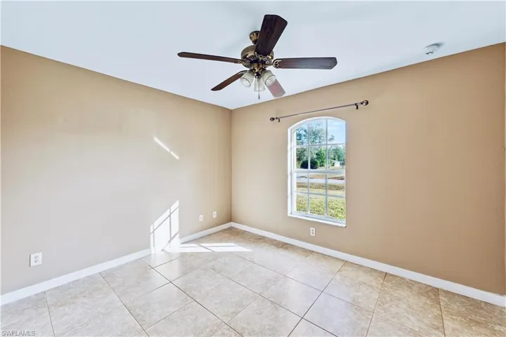 Spare room featuring ceiling fan and light tile patterned floors