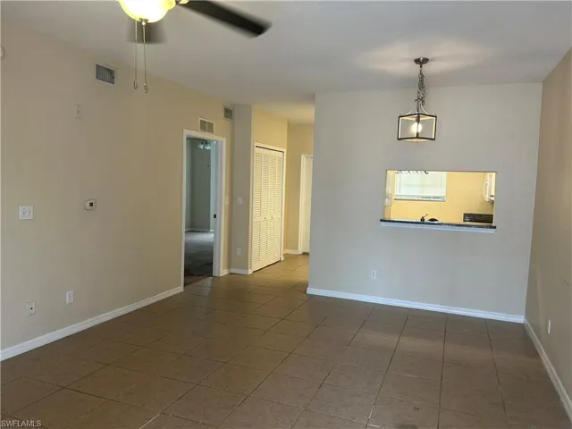 Spare room featuring ceiling fan and dark tile patterned flooring