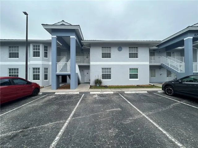 View of apartment building / complex with stairway and uncovered parking
