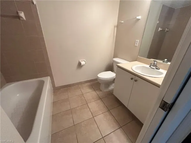 Full bath with vanity and light tile patterned flooring