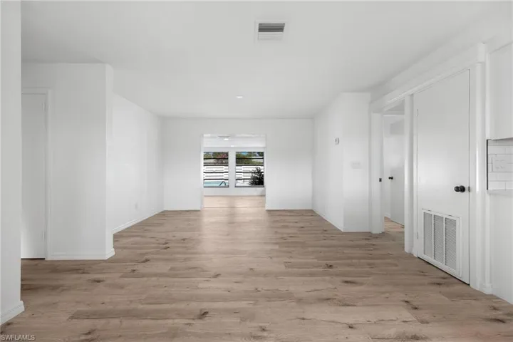Empty room featuring light wood finished floors, baseboards, and visible vents