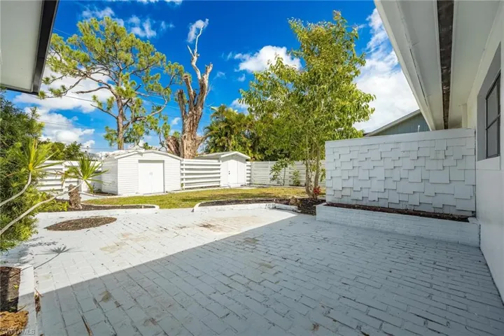 View of patio featuring a storage shed, a fenced backyard, and an outbuilding