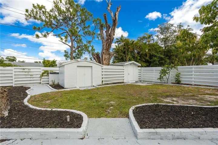 View of yard featuring a fenced backyard, an outdoor structure, and a storage unit