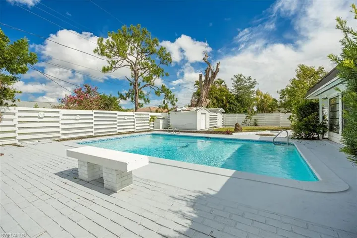 View of pool with a shed, a patio, a fenced backyard, and an outbuilding