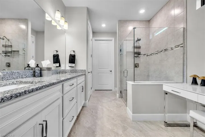 -featuring floor to ceiling tile and frameless glass walk in shower