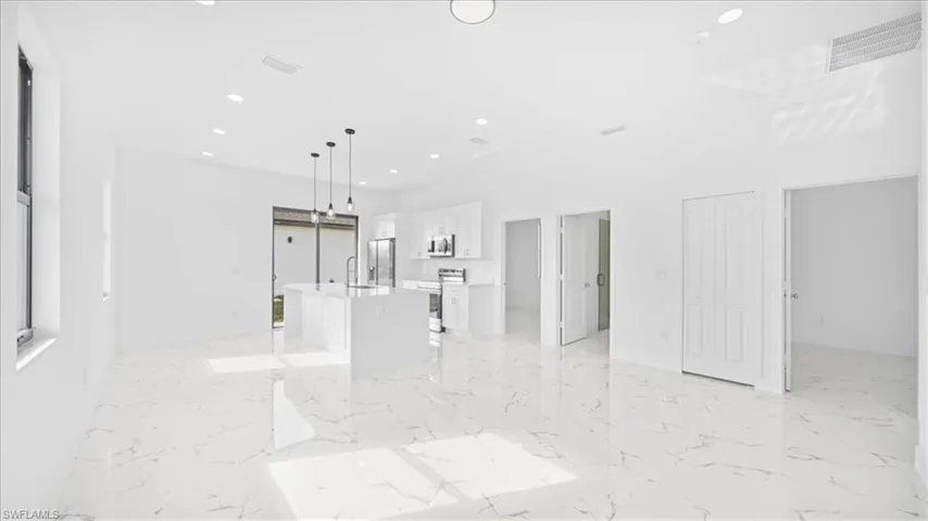 Unfurnished living room featuring recessed lighting and a sink