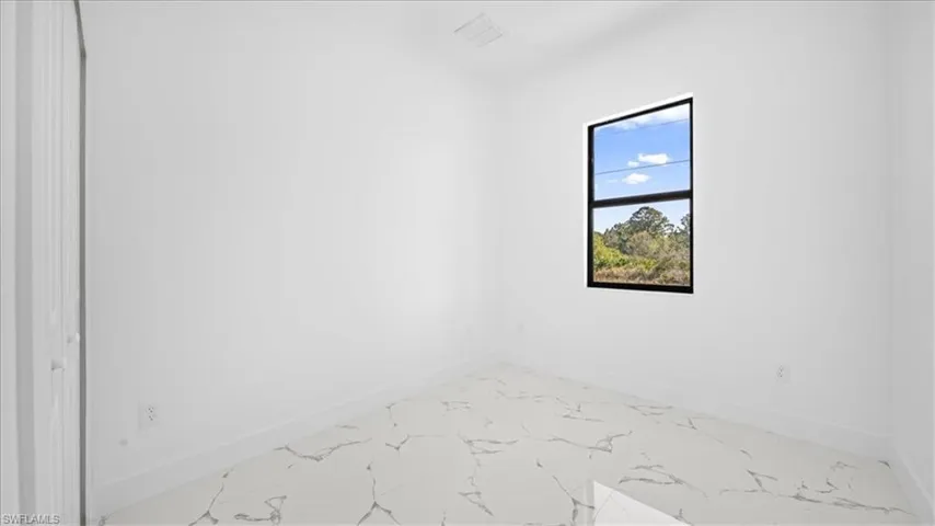 Spare room with baseboards and light marble finish flooring