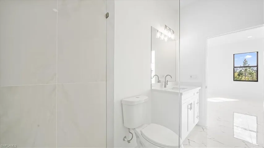 Bathroom featuring vanity and light marble finish flooring