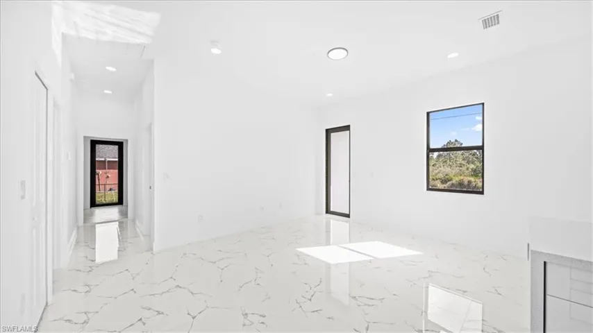 Spare room featuring light marble finish flooring and recessed lighting