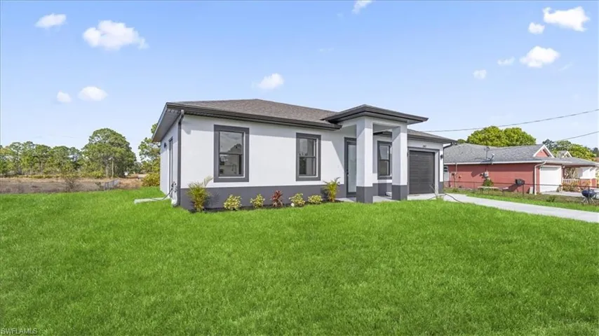 Prairie-style home featuring a front yard, stucco siding, and concrete driveway