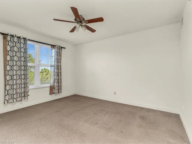 Unfurnished room featuring carpet floors and ceiling fan