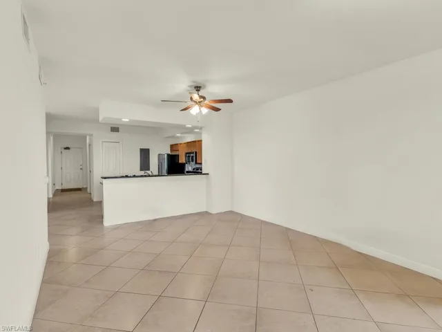 Unfurnished living room featuring light tile patterned flooring and ceiling fan