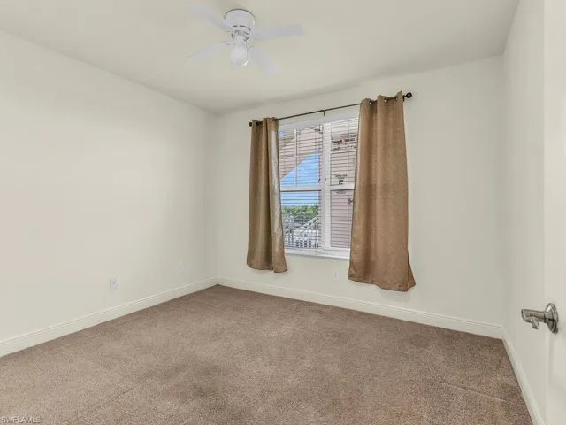 Empty room with carpet and ceiling fan