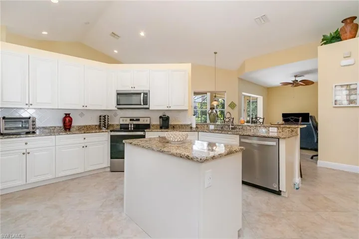 Kitchen featuring stainless appliances, granite countertops and island.