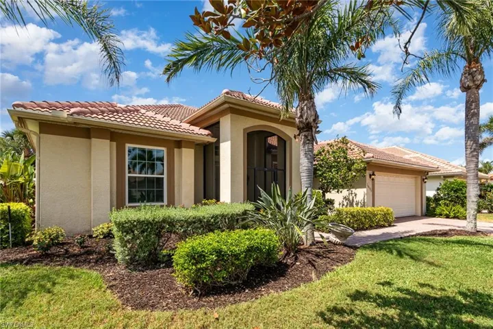 Mediterranean style house featuring 2 car garage, paver driveway and beautifully landscaped front yard.