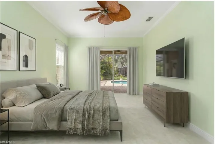 Virtually Edited. Master Bedroom with a sunroom, access to outside, multiple windows, light colored carpet, and ornamental molding