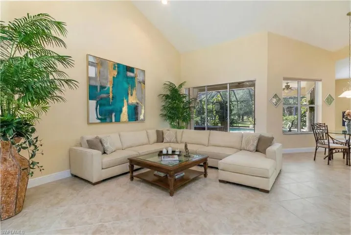 Virtually Edited. Living room featuring lofted ceiling, tile patterned flooring, and a sunroom