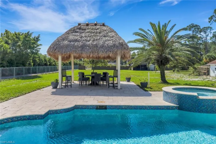 Pool with a lawn, a gazebo, a patio area, fence, and an in ground hot tub