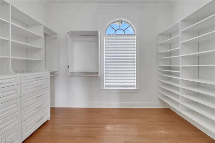 Walk in closet with light wood finished floors