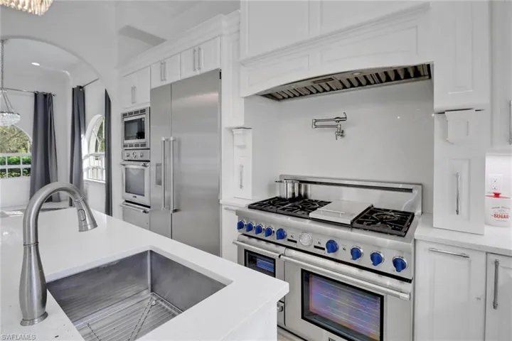 Kitchen with white cabinets, light countertops, and built in appliances