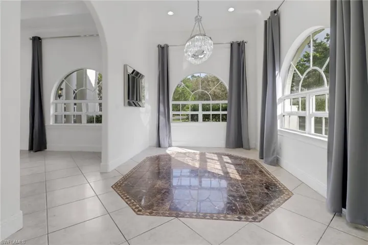 Entrance foyer with a healthy amount of sunlight, light tile patterned floors, a chandelier, and recessed lighting