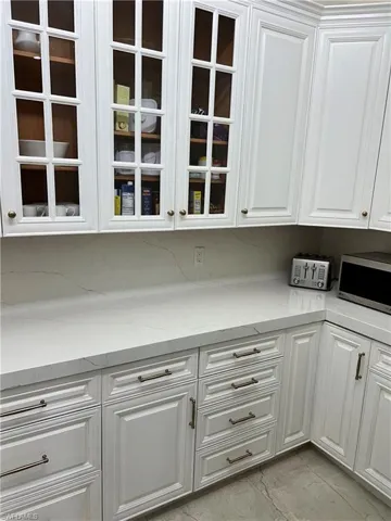 Kitchen with white cabinets and light stone countertops