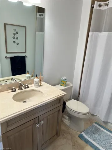 Full Guest bath featuring tile patterned floors, toilet, and vanity