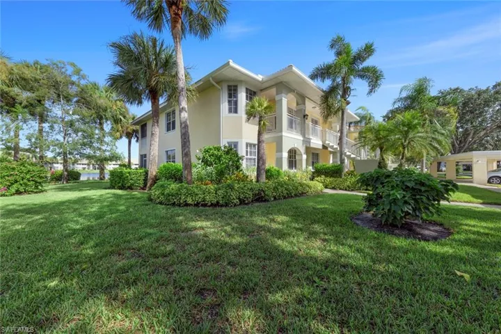 View of side of house with a balcony and a front yard