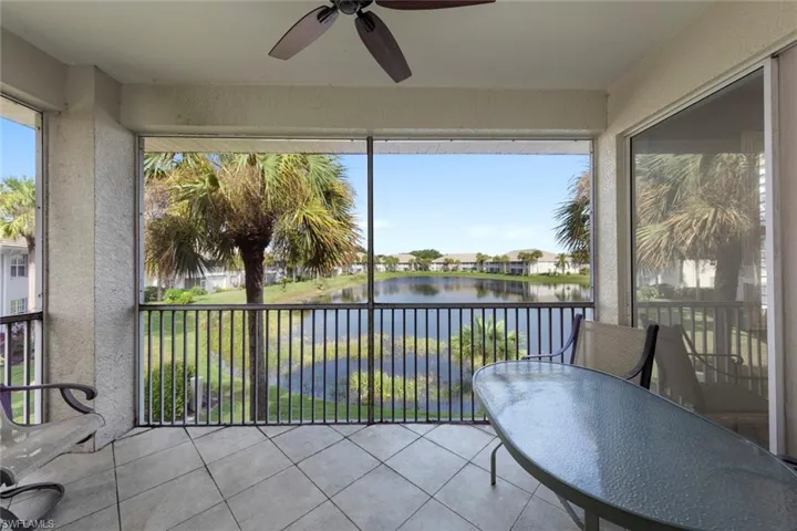 Sunroom featuring ceiling fan and a water view