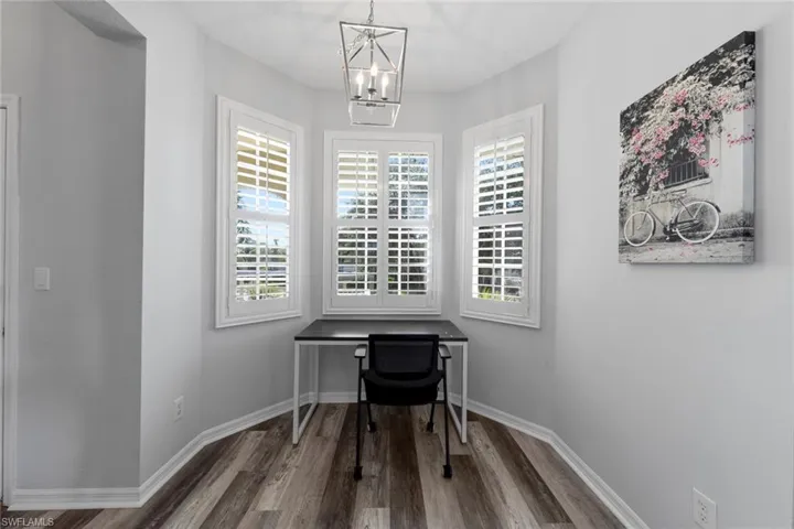 Office space featuring an inviting chandelier and hardwood / wood-style floors