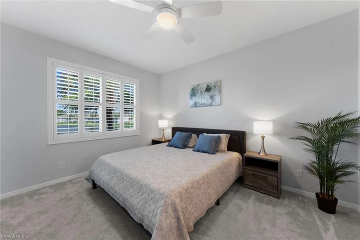 Bedroom with ceiling fan and light carpet