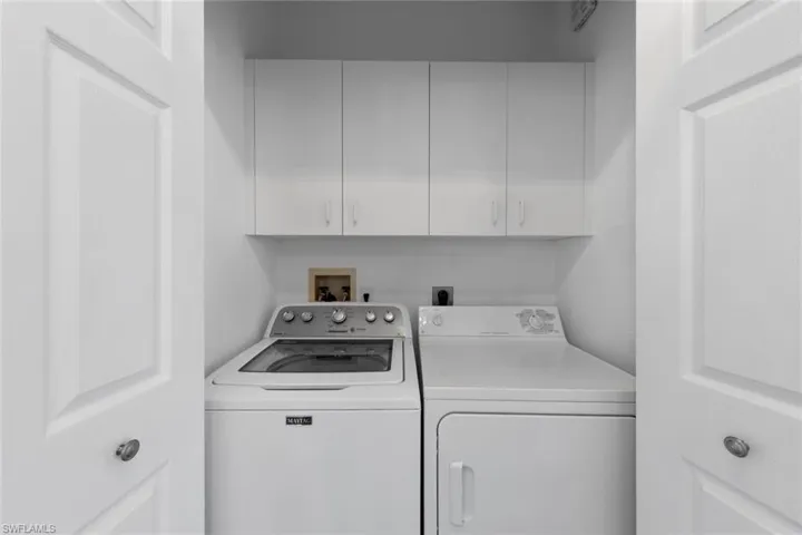 Laundry room featuring cabinets and washer and dryer