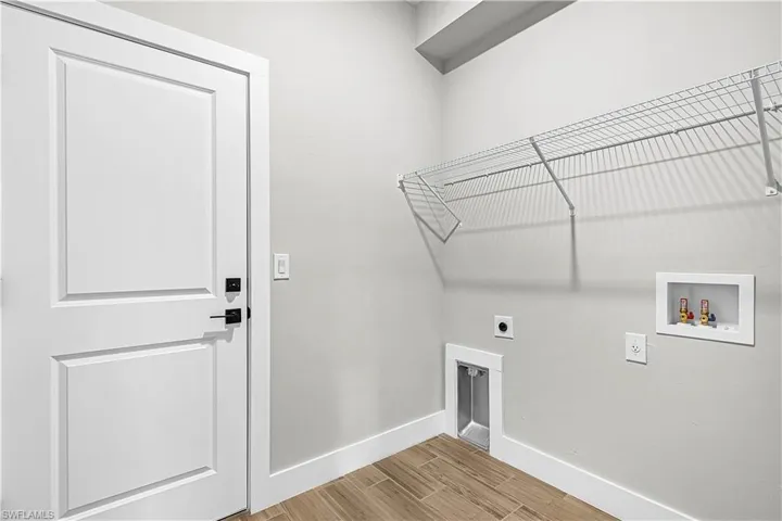Laundry area featuring wood finish floors, electric dryer hookup, and hookup for a washing machine