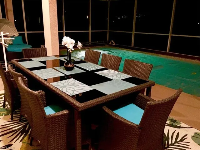 Patio at night featuring a pool