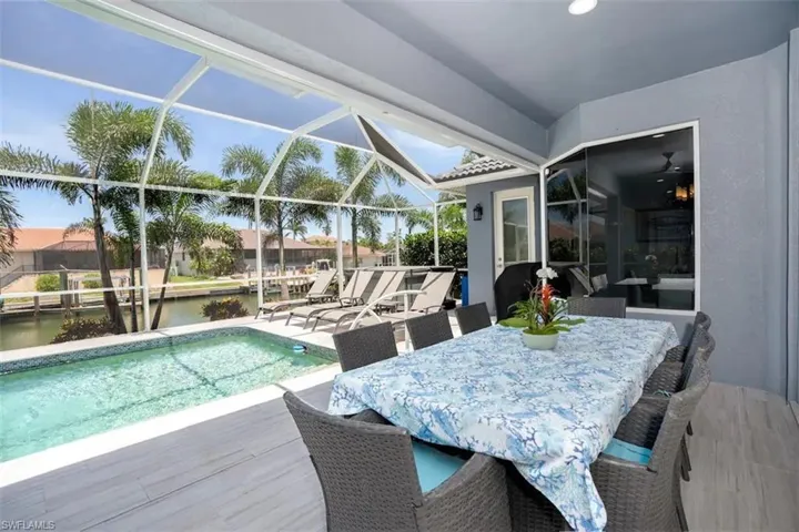 View of swimming pool with a lanai, a patio, and a water view