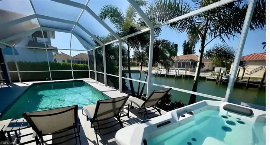 View of pool featuring a lanai, a patio, and a water view