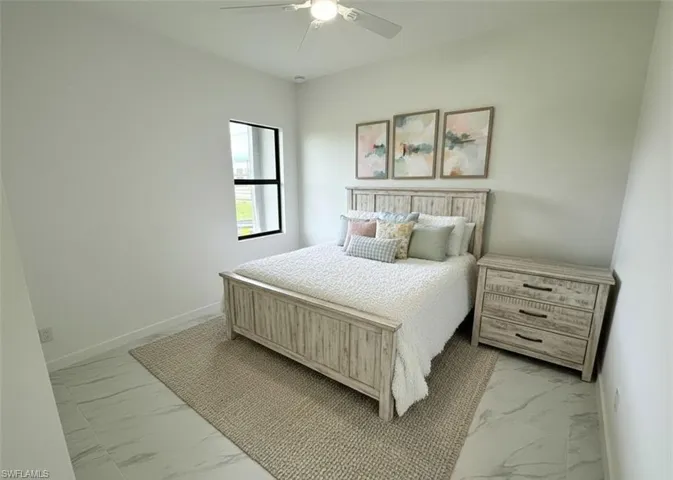 Bedroom with light marble finish floors and a ceiling fan