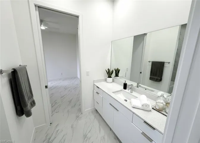 Bathroom with vanity and light marble finish floors