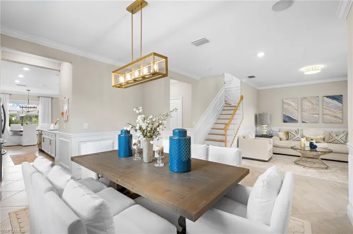 Tiled dining area featuring crown molding and an inviting chandelier