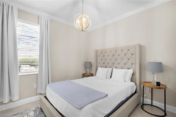 Bedroom with ornamental molding and an inviting chandelier
