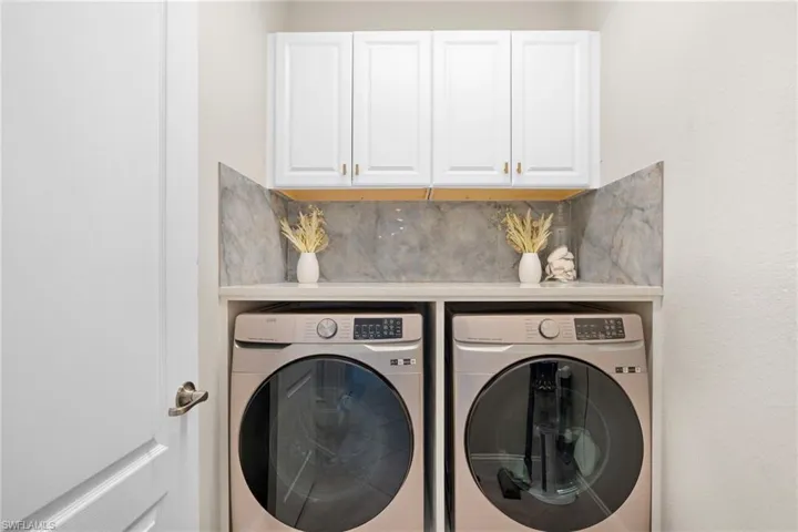 Laundry area featuring cabinets and separate washer and dryer