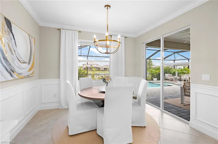 Dining area featuring crown molding, a chandelier, and light tile patterned flooring