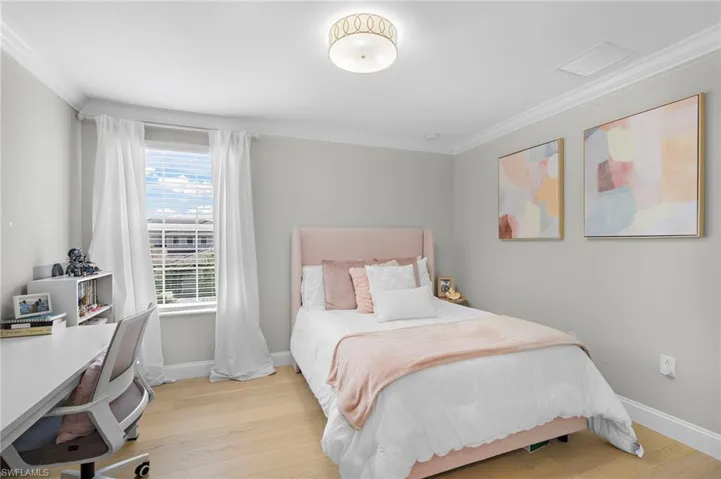 Bedroom featuring crown molding and light hardwood / wood-style floors