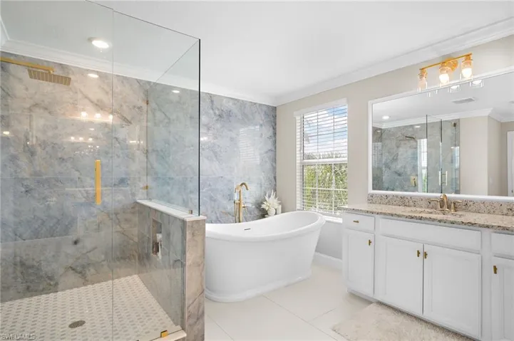 Bathroom featuring tile patterned flooring, vanity, ornamental molding, and independent shower and bath