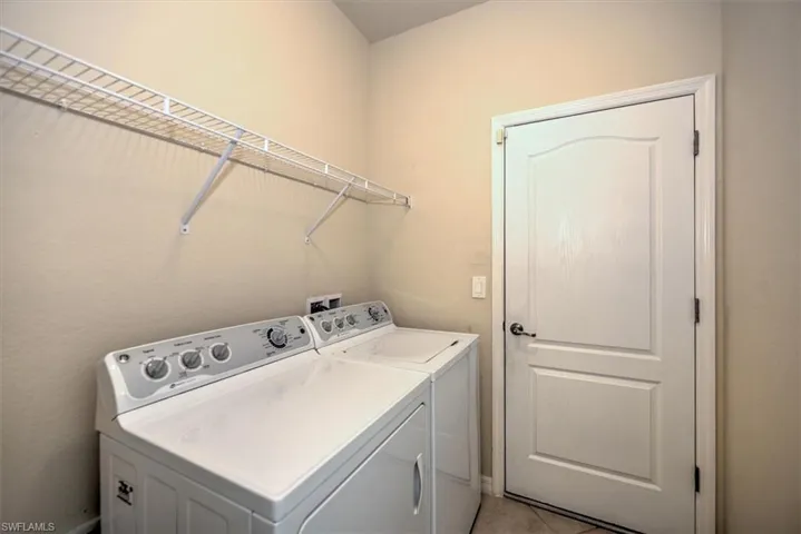 Full size tiled laundry room with overhead light!